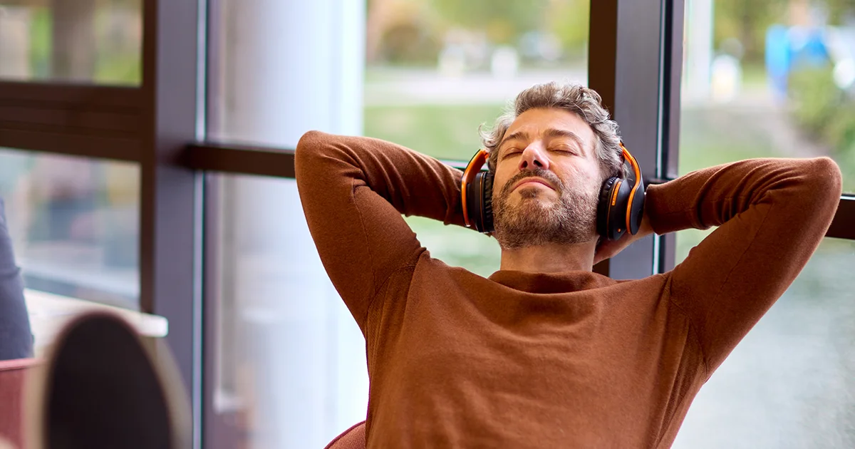 Relaxed professional with headphones enjoying a moment of calm, reflective of efficient reporting processes
